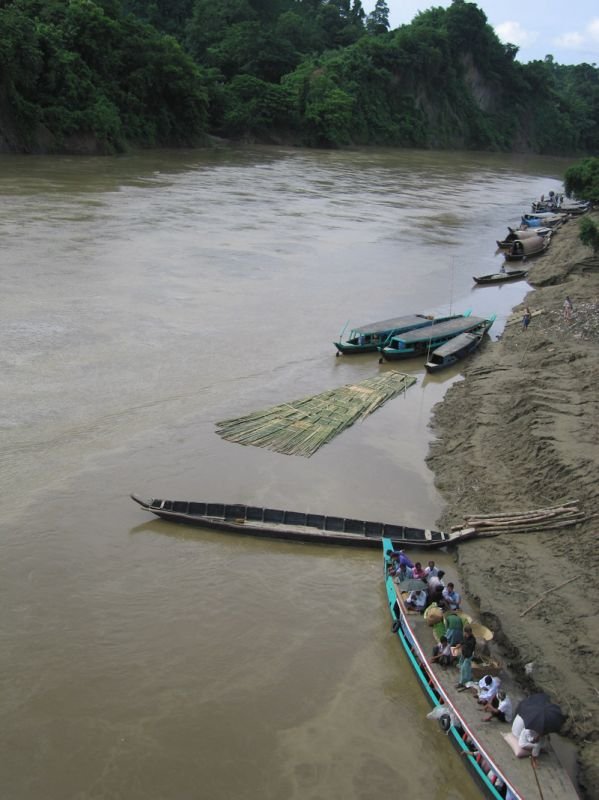 boats & bamboo rafts carry people & their goods to market & to different villages. the people on the roof & inside in the boat on the bottom right are waiting to go back to their villages at the end of the market day in town
