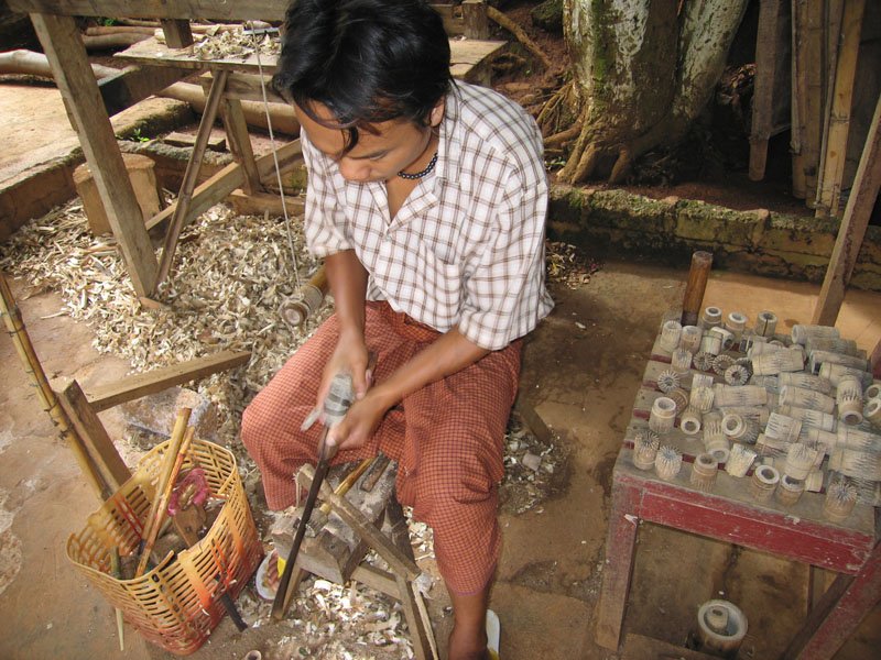 carving wood into one of the pieces of the parasol
