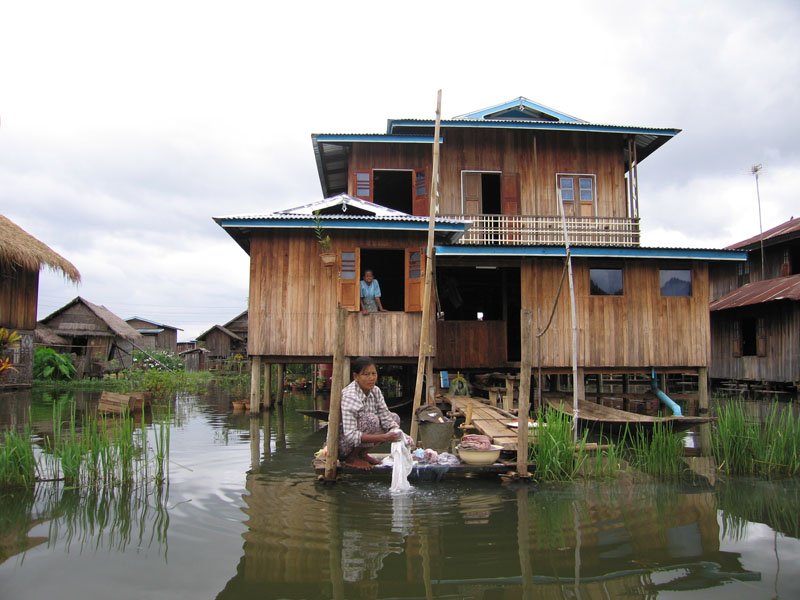 doing laundry. there are many of these villages on the lake. since the lake isn't deep (although it's big), houses are built on stilts and people have floating vegetable plots and gardens
