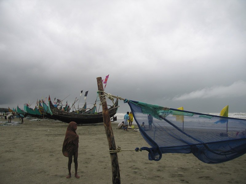 the lungi (known as "sarong" in s.e. asia) is also versatile. this little boy pulled up his lungi to make it into a hood and body covering - against the drizzle
