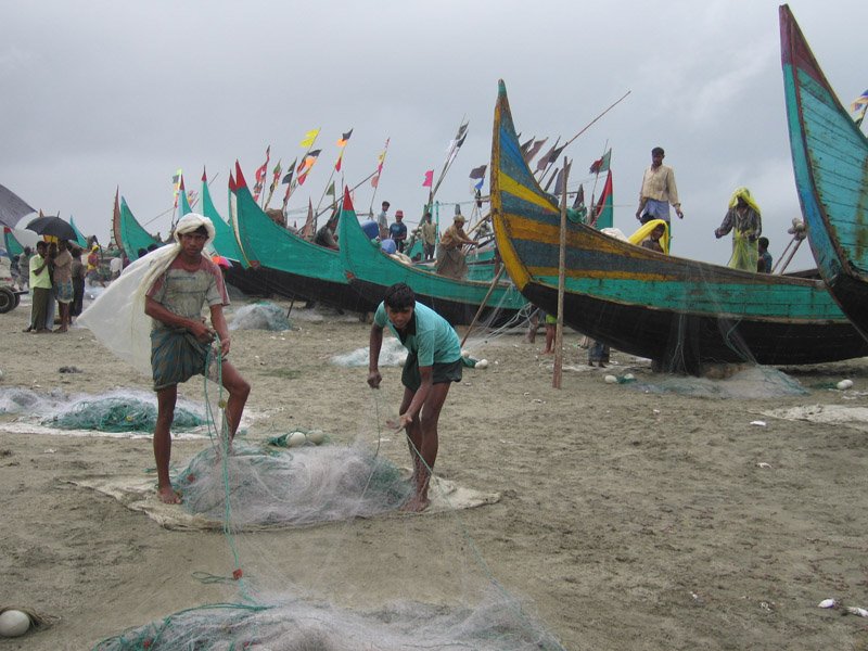 two of the fishermen folding up nets after a day's work
