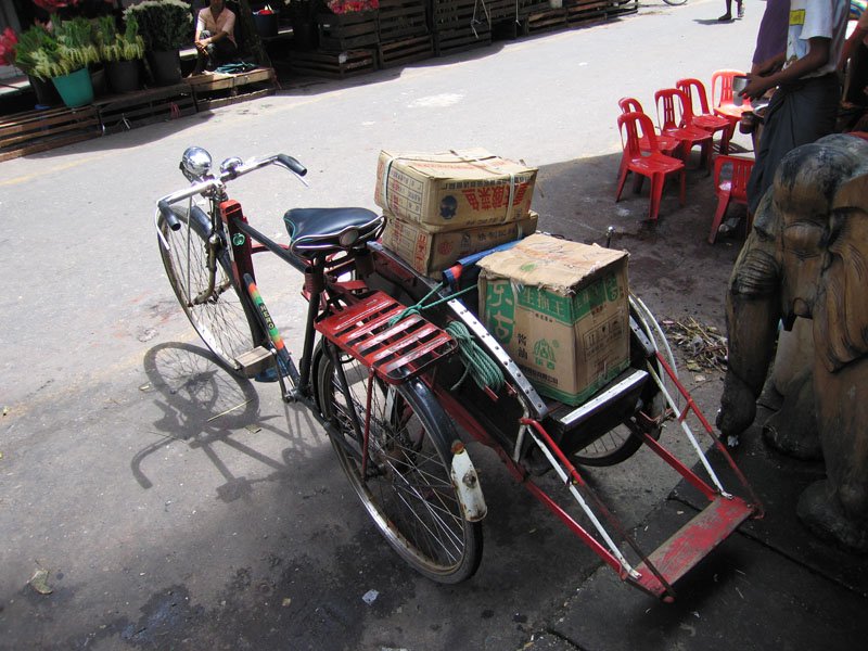 the Myanmar version of a rickshaw - the passegers sit in a sidecar, one facing forward, one back

