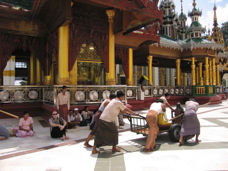 pushing a buddha statue on a cart. apparently, hundreds of Monday born people sweep the Shwe Dagon on Mondays (and Tuesday born do so on Tuesdays and so on for the other days of the week) to earn merit
