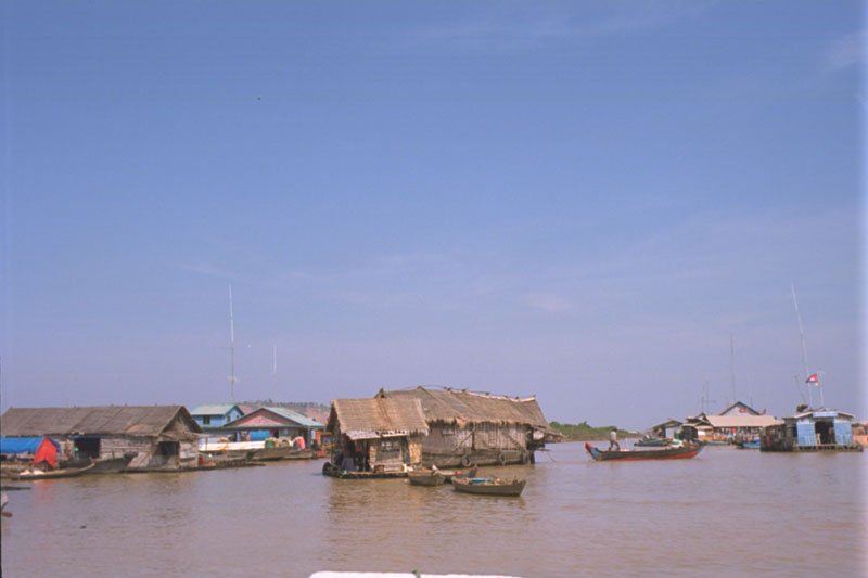 a house moving to another location on the lake - the boat in front is pulling the 2 houses which are attached together
