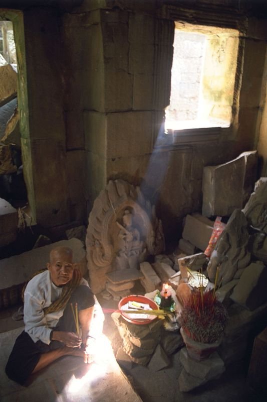 a little shrine that this old woman has set up in the ruins of the temple
