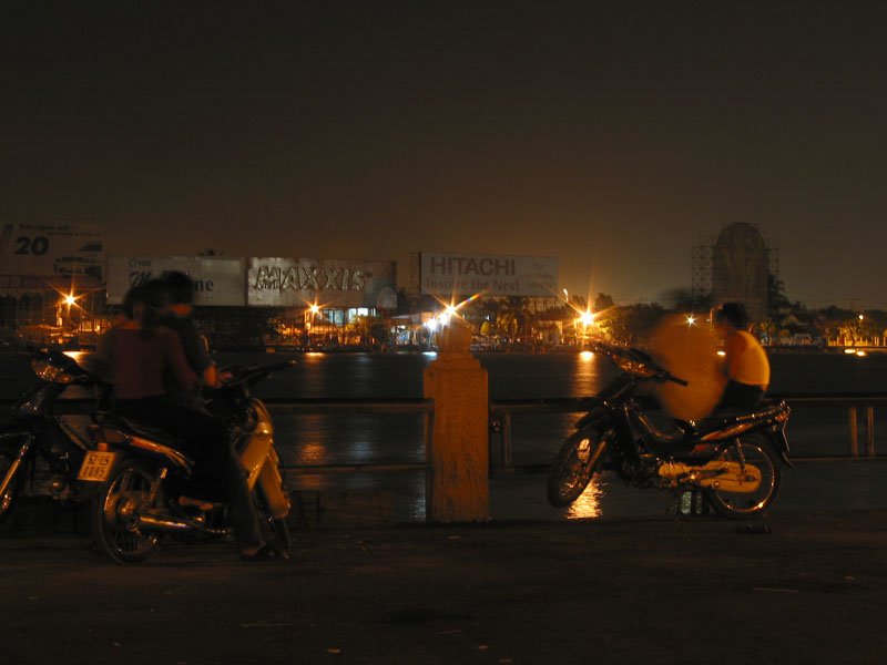 couples hanging out and making out by the Saigon River on their motorbikes at night
